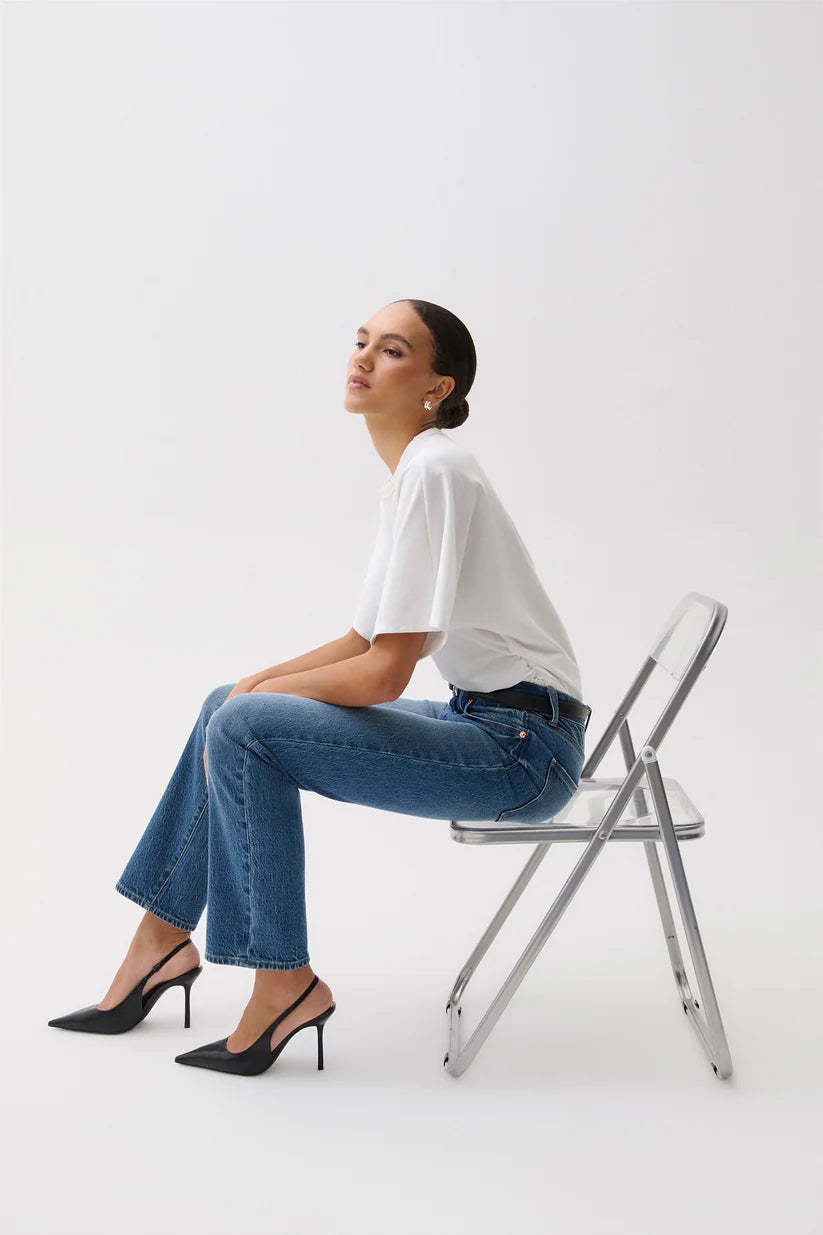 Woman sitting on a transparent chair against a white background