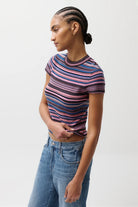 Person wearing a striped shirt and jeans on a plain background
