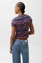 Person wearing a striped shirt and jeans on a white background