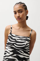 Woman wearing a zebra print dress against a white background