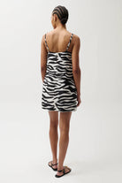 Person wearing a zebra print dress on a white background