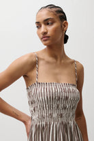Woman wearing a patterned dress against a plain background