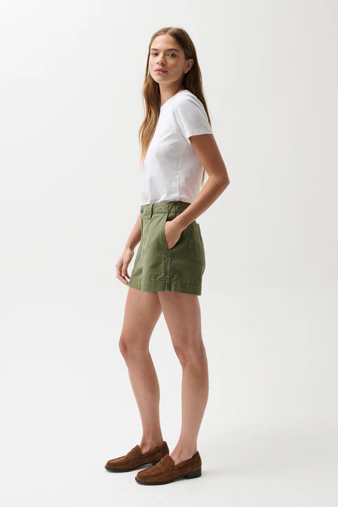 Woman wearing a white t-shirt and green skirt on a white background