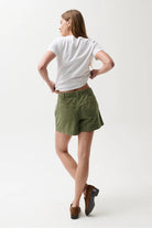 Person wearing a white t-shirt and green shorts on a white background