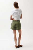 Person wearing a white t-shirt and green shorts on a white background