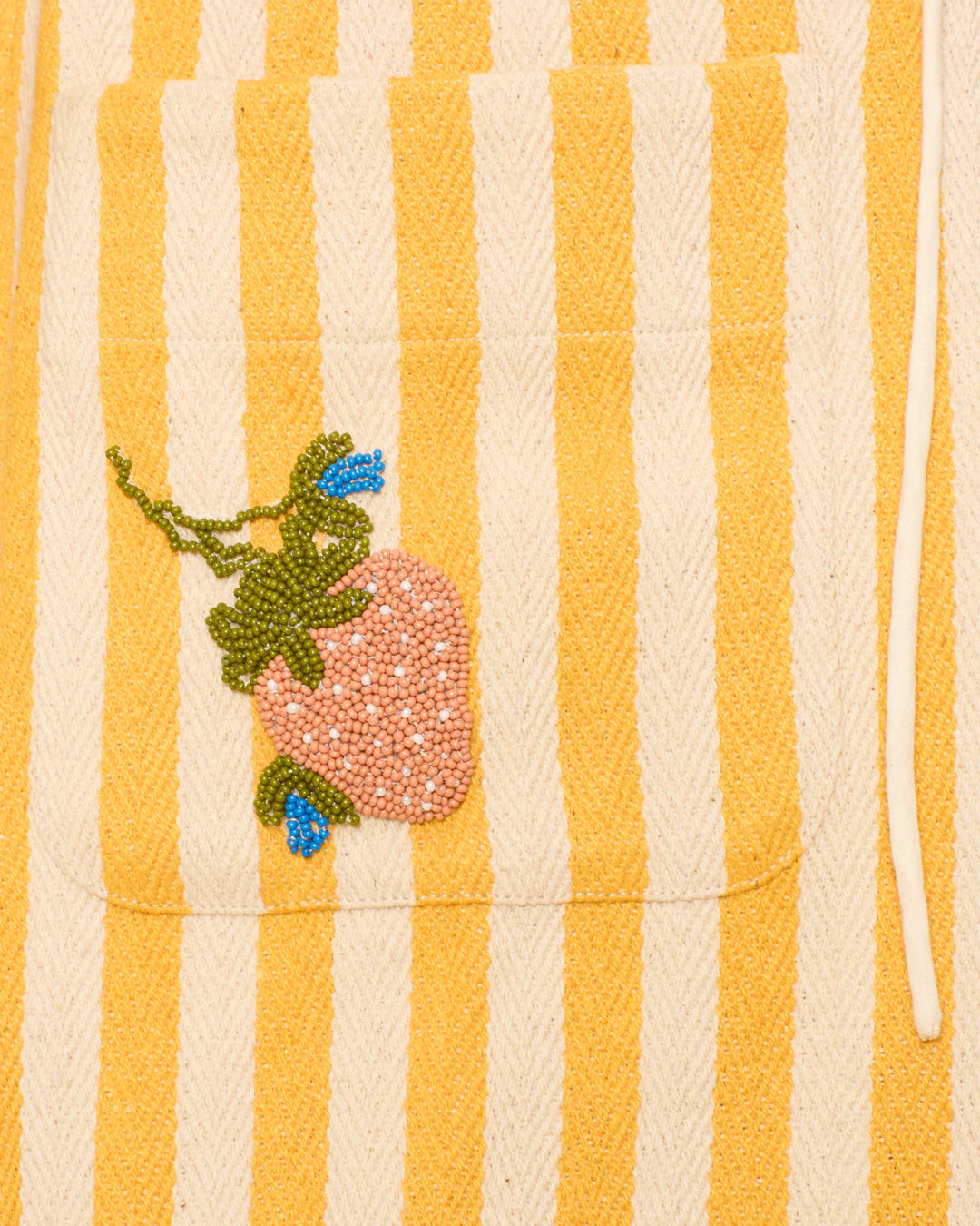 Striped fabric with embroidered flower design on a yellow and white background