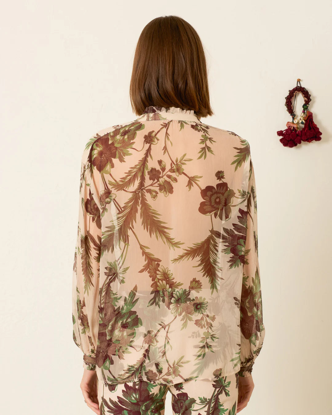 Woman wearing a floral blouse with a neutral background