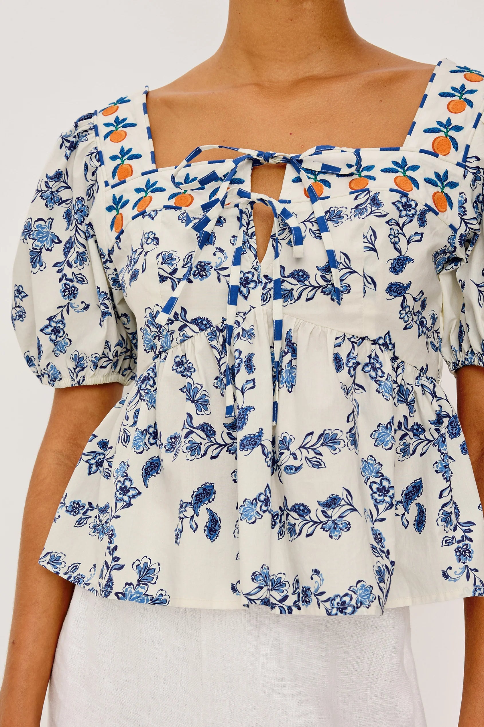 Floral blouse with blue and orange patterns on a plain background