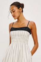 Woman wearing a black and white dress against a plain background