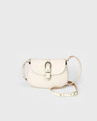 White handbag with gold accents on a light gray background