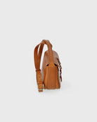 Brown leather backpack on a light gray background