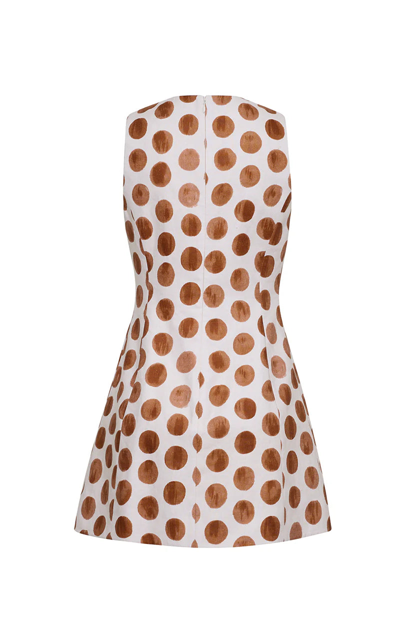 White sleeveless dress with brown polka dots on a white background