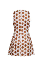 White sleeveless dress with brown polka dots on a white background