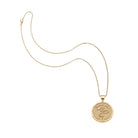 Gold necklace with a round pendant on a white background