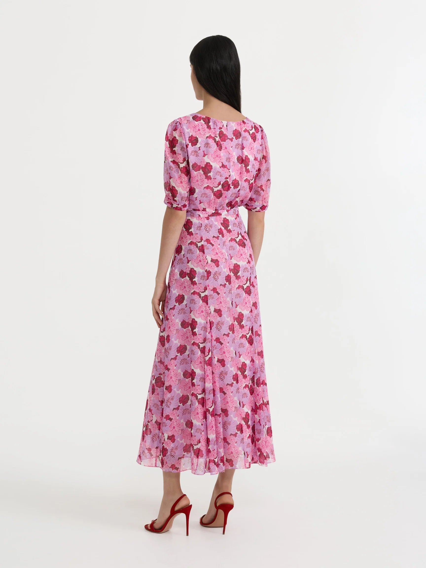 Woman wearing a pink floral dress on a white background