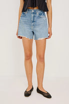 Person wearing light blue denim shorts on a white background