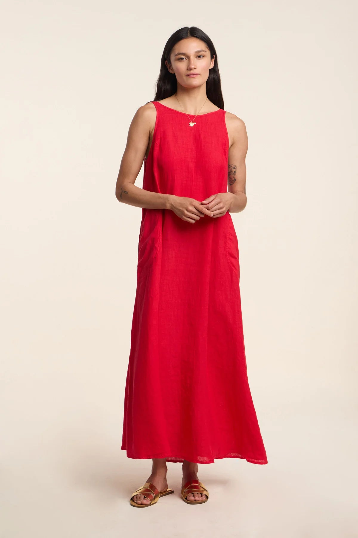 Woman wearing a red sleeveless dress on a beige background