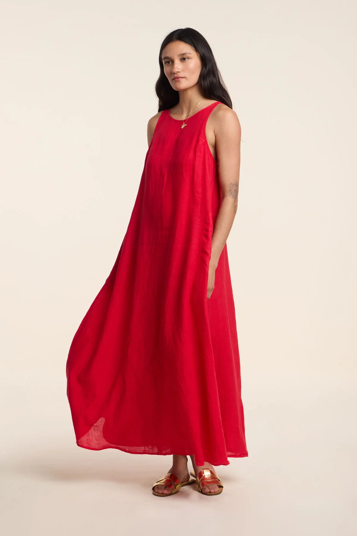 Woman wearing a red sleeveless dress on a beige background