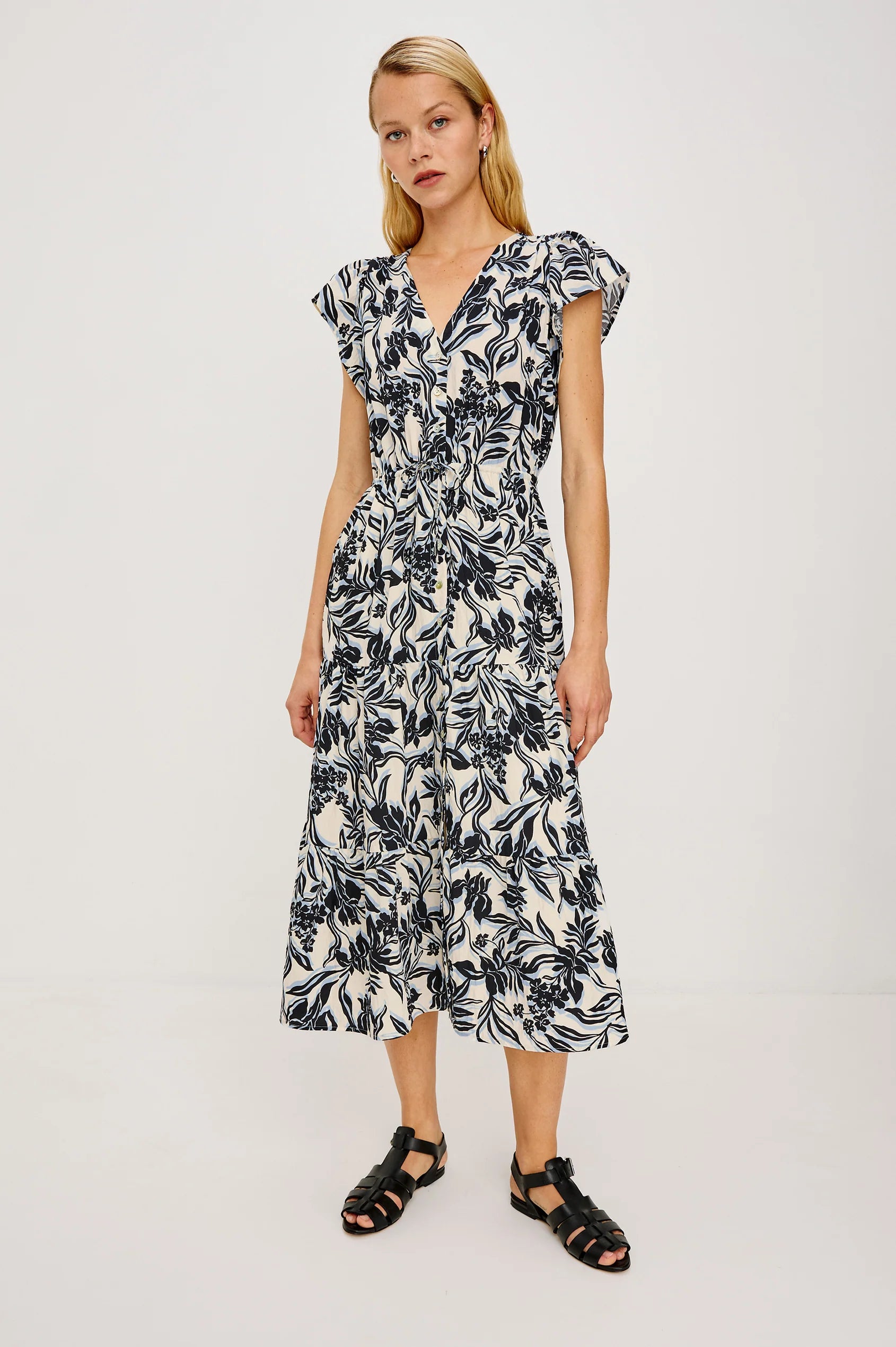 Woman wearing a black and white floral dress on a light gray background