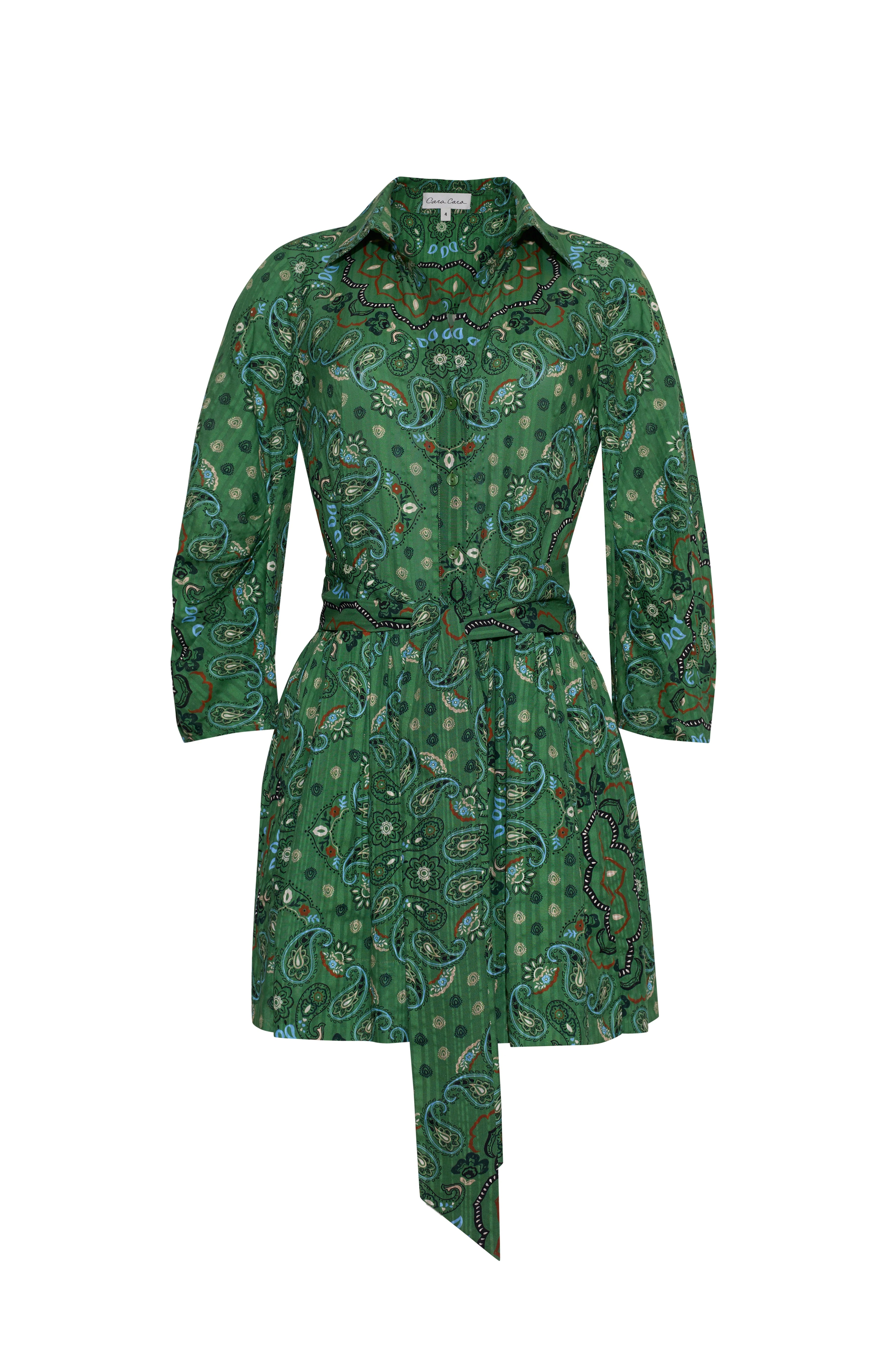 A green long-sleeve collared shirt dress with a paisley and medallion pattern, featuring a matching waist tie belt and a tie-down detail at the hem, shown against a plain white background.