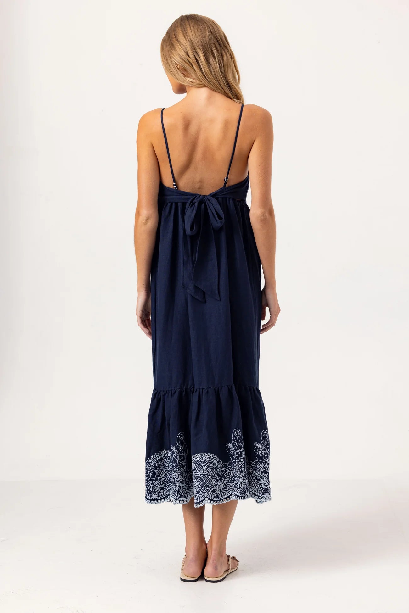 Navy blue dress with lace details on a white background