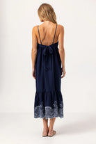 Navy blue dress with lace details on a white background