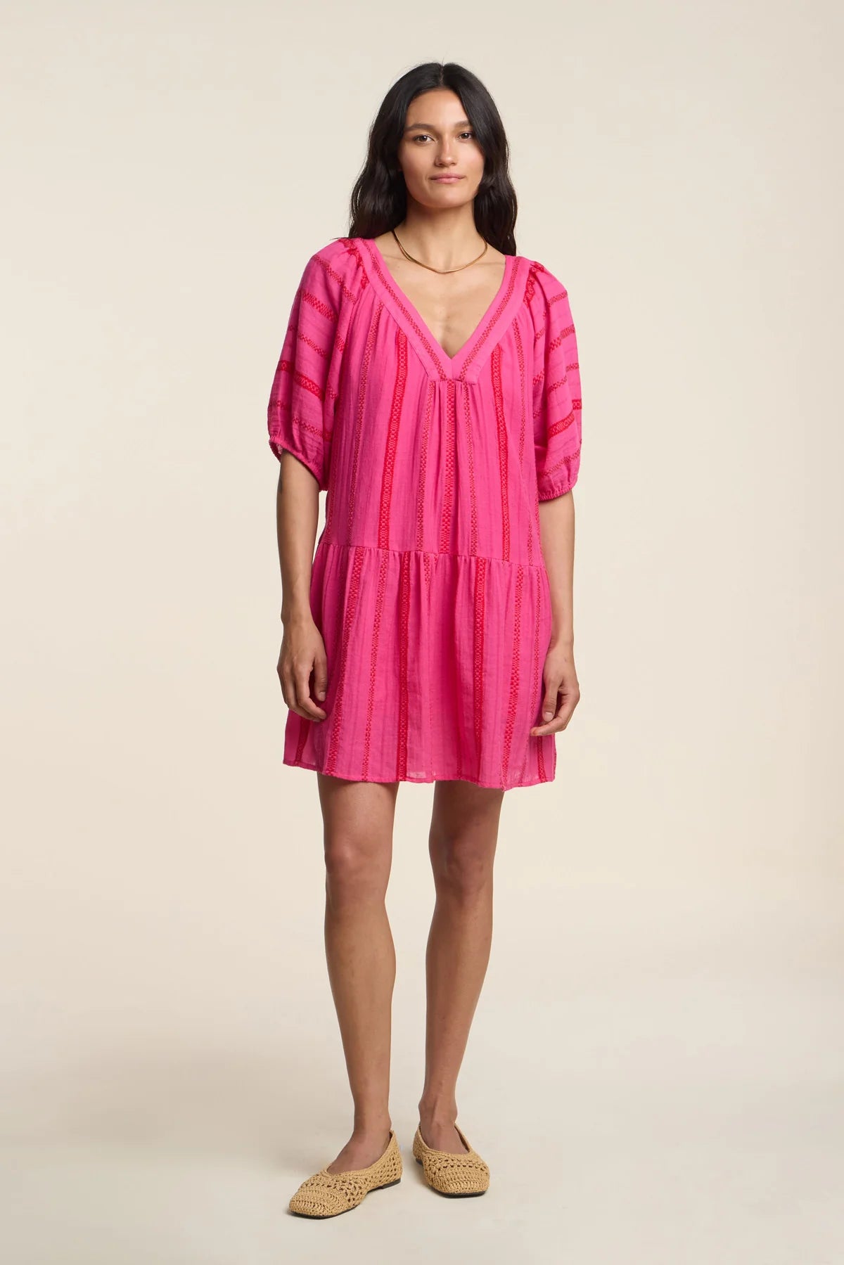 Woman wearing a pink dress on a beige background