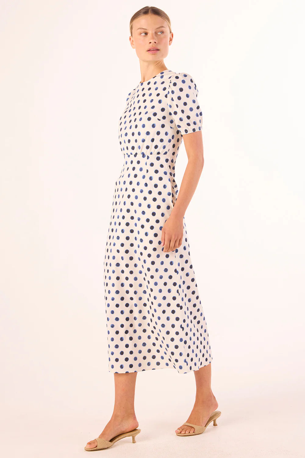 Woman wearing a polka dot dress on a white background