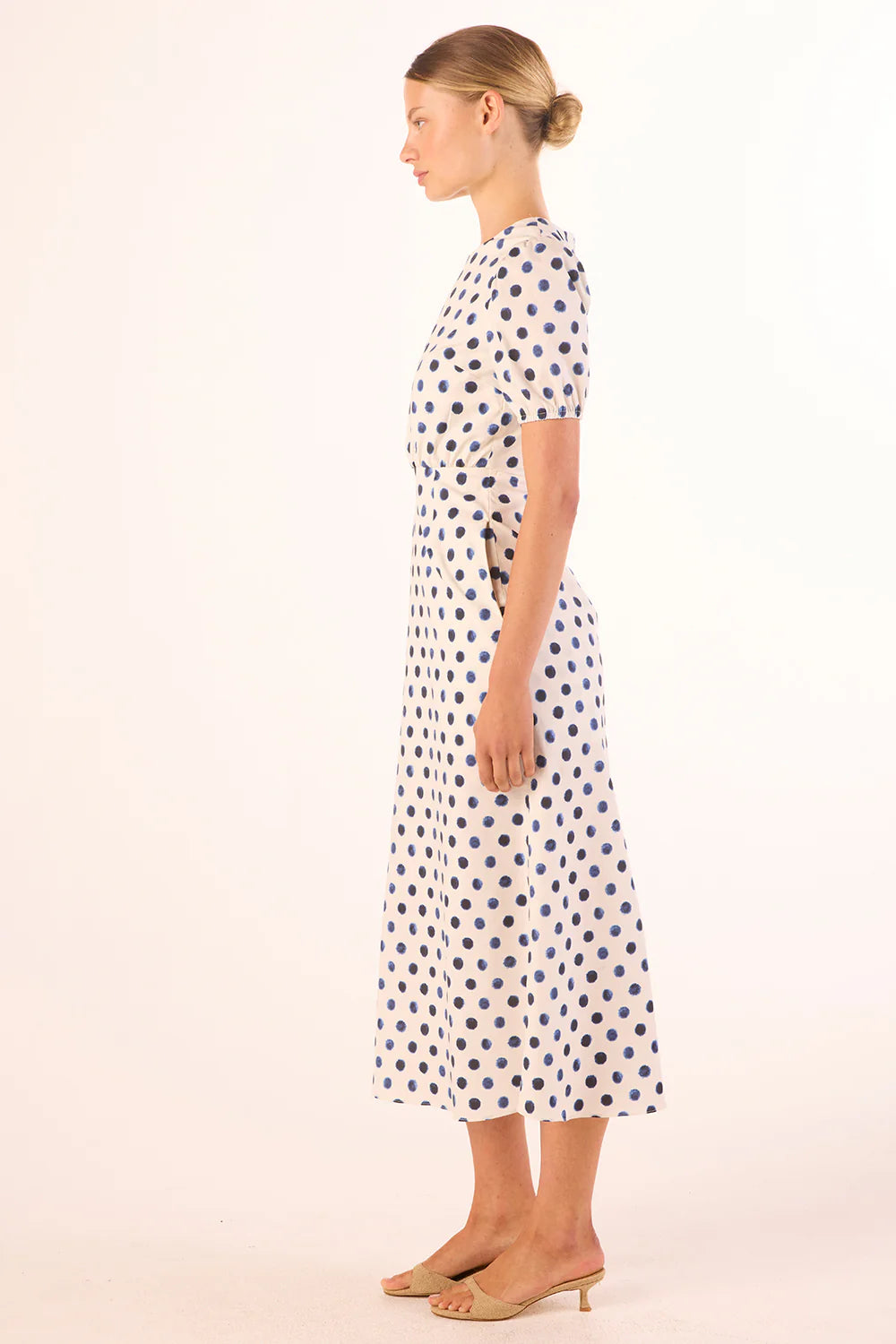 Woman wearing a polka dot dress on a white background