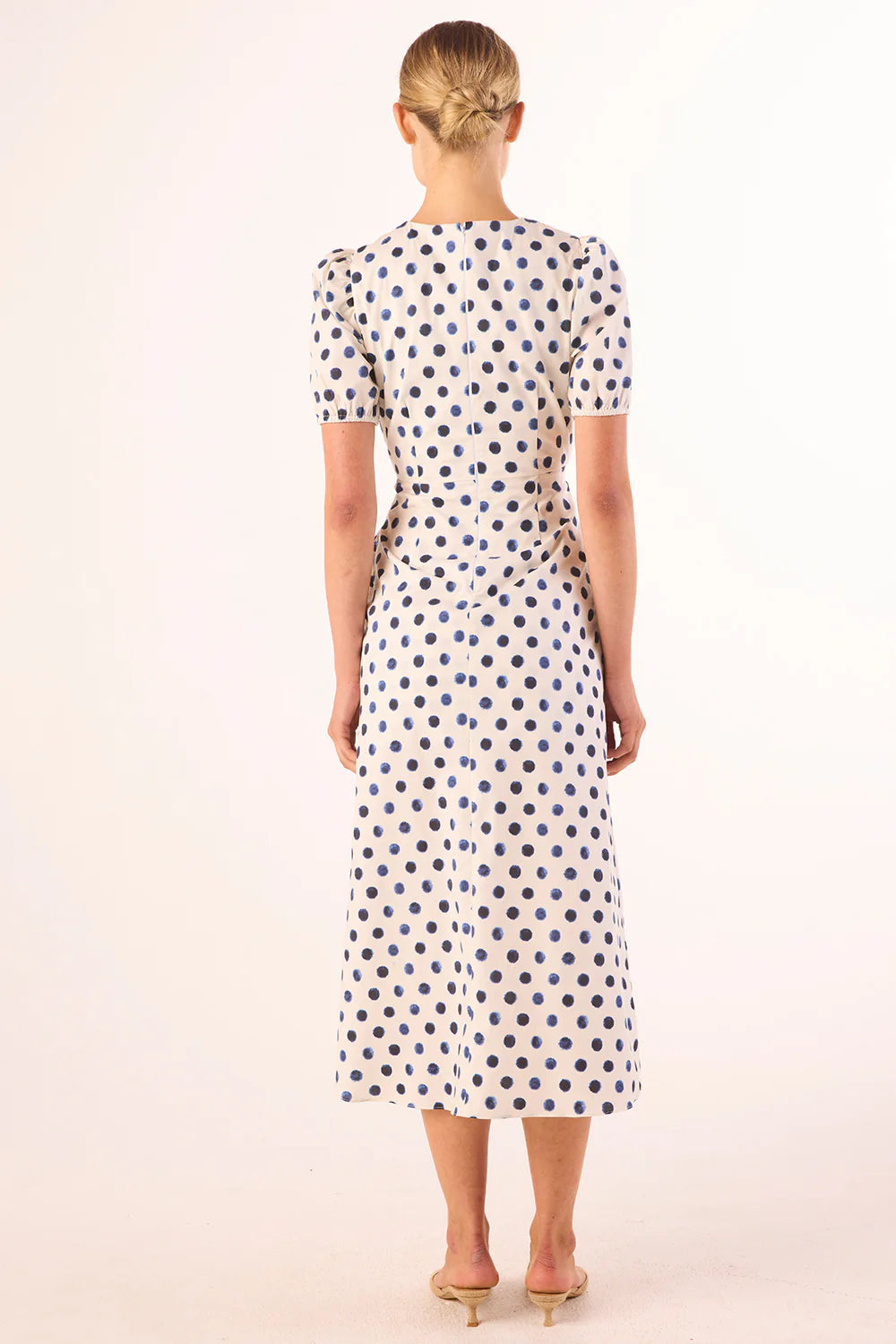 Woman wearing a polka dot dress on a white background