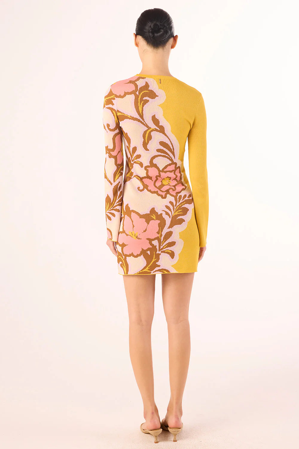 Woman wearing a floral dress with a yellow background
