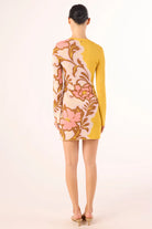 Woman wearing a floral dress with a yellow background