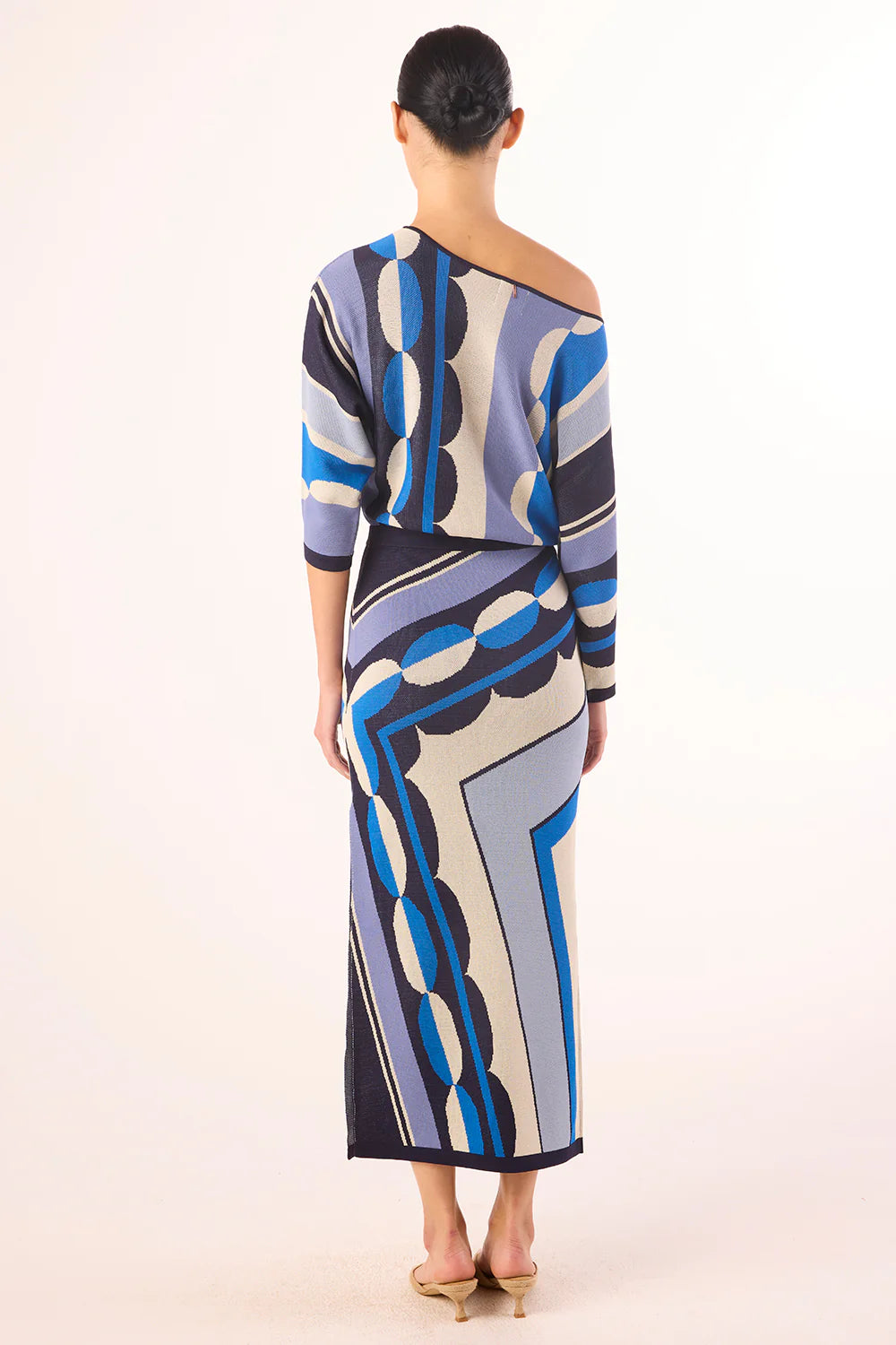 Woman wearing a patterned dress on a white background