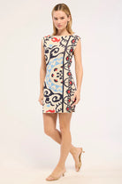 Woman wearing a colorful patterned dress on a white background