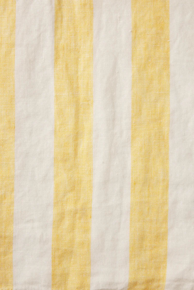 Fabric with yellow and white vertical stripes on a textured background