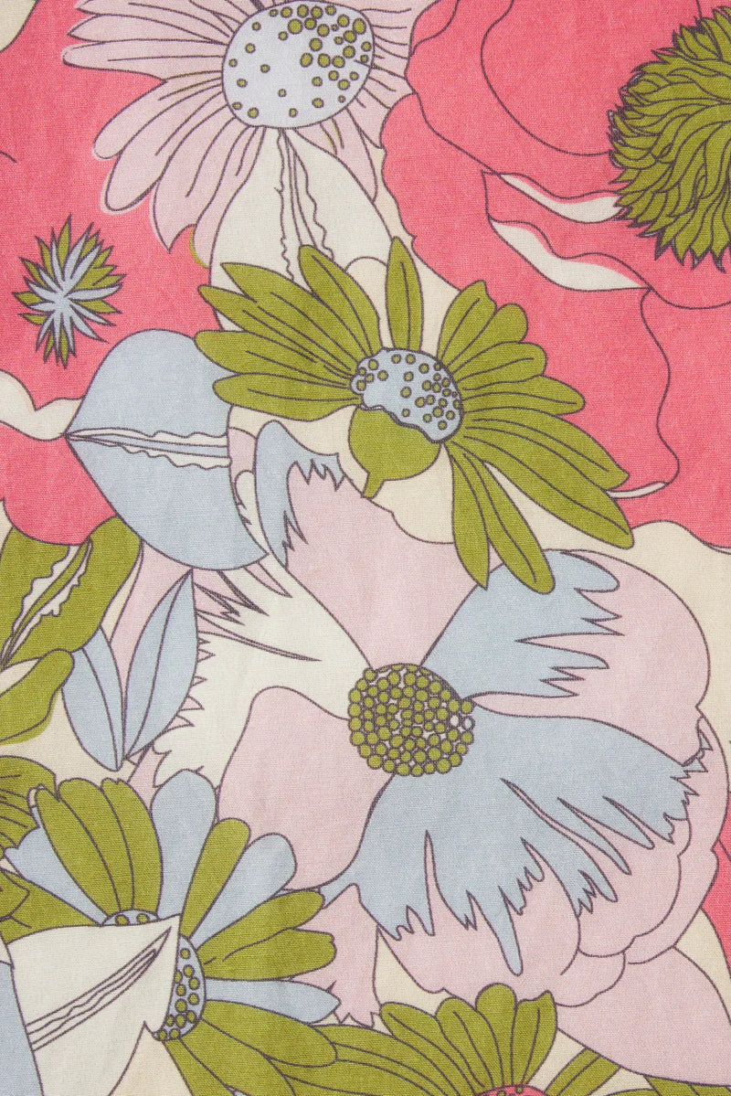 Floral pattern with green, blue, and pink flowers on a pink background
