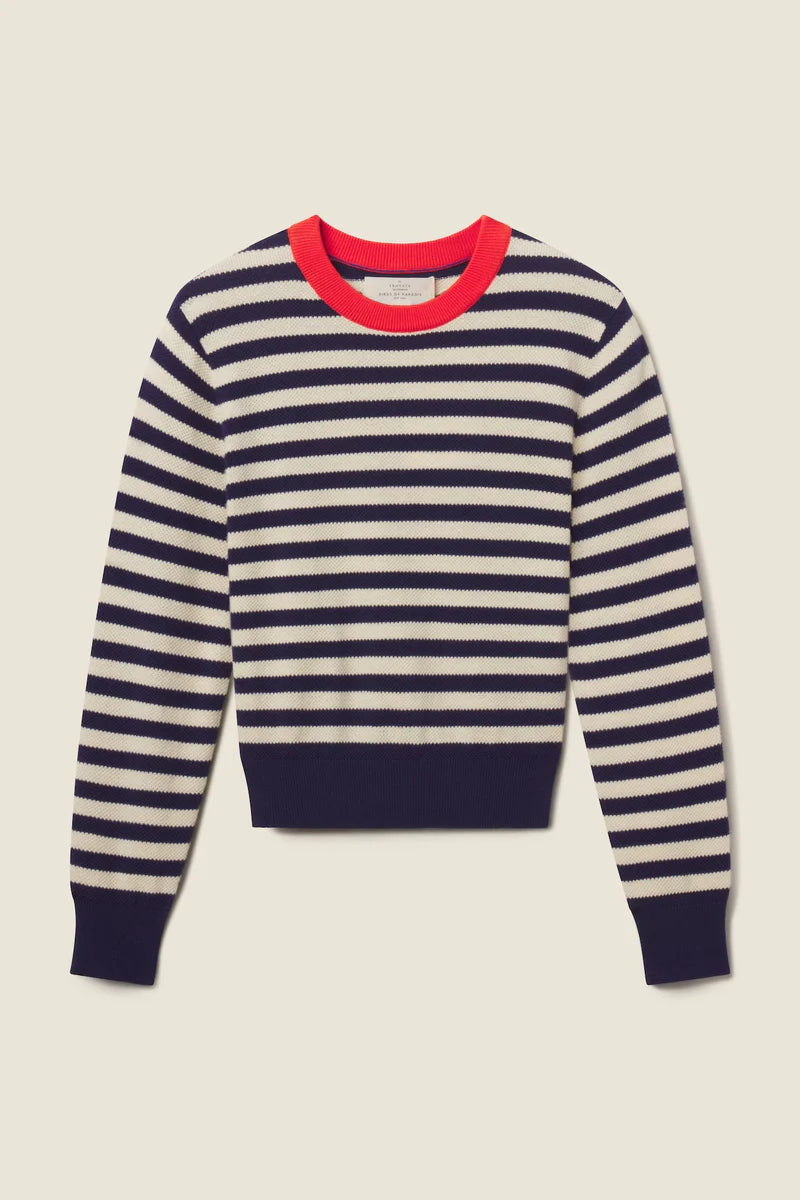 Navy and white striped sweater with red neckline on a beige background