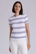 Woman wearing a white t-shirt with blue and gold stripes on a plain background