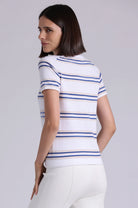 Woman wearing a white t-shirt with blue and gold stripes on a plain background