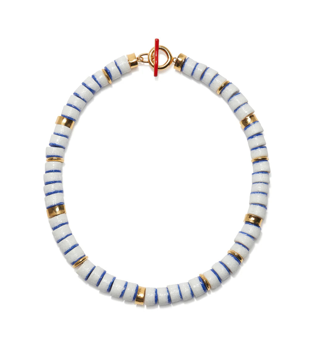 Bracelet with white and blue striped beads and gold accents on a white background