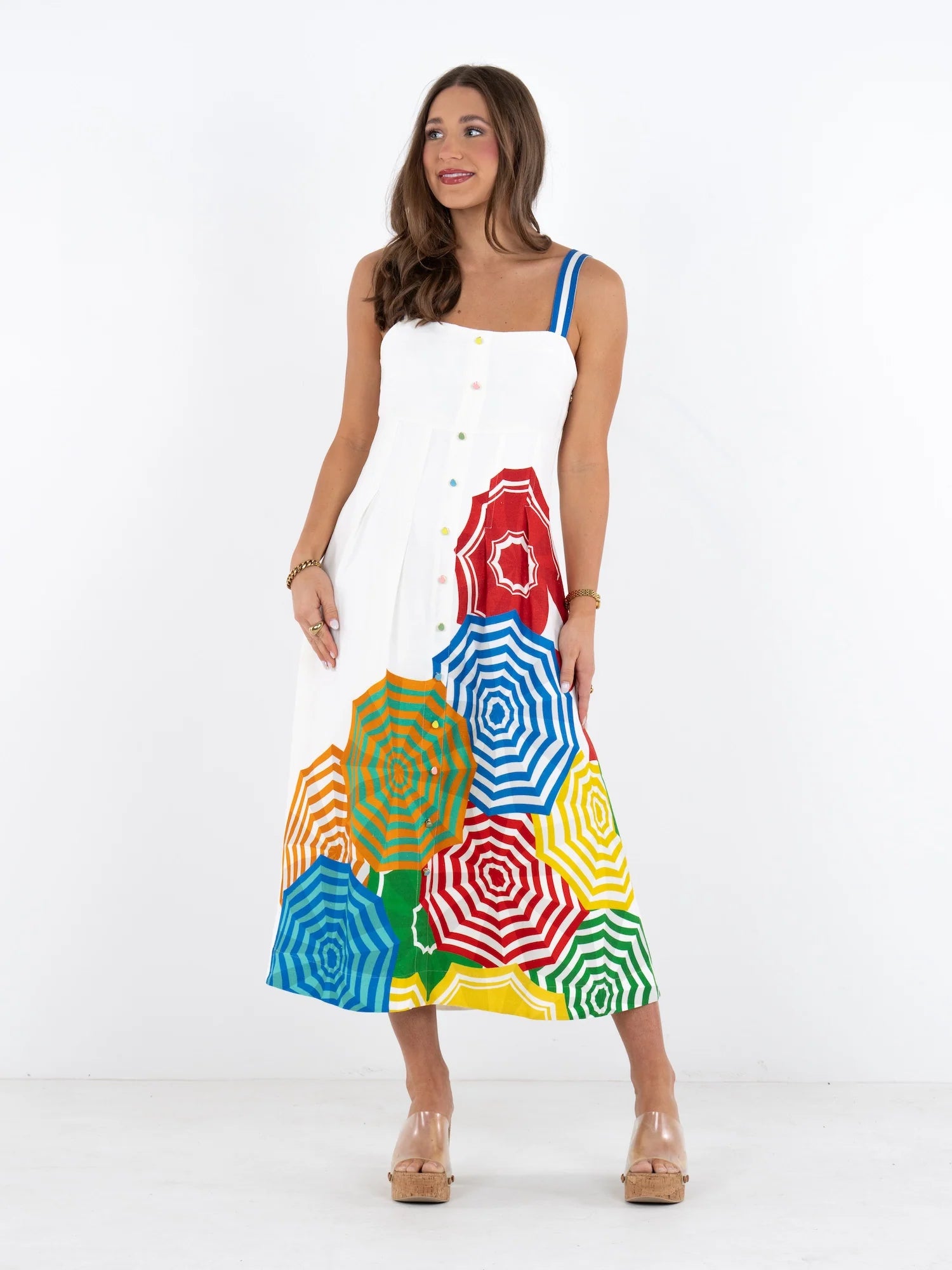 Woman wearing a colorful dress with geometric patterns on a white background