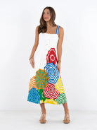 Woman wearing a colorful dress with geometric patterns on a white background