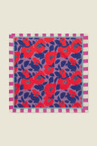 Square fabric sample with red and blue floral pattern on a purple background