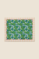 Fabric swatch with green floral pattern on a beige background