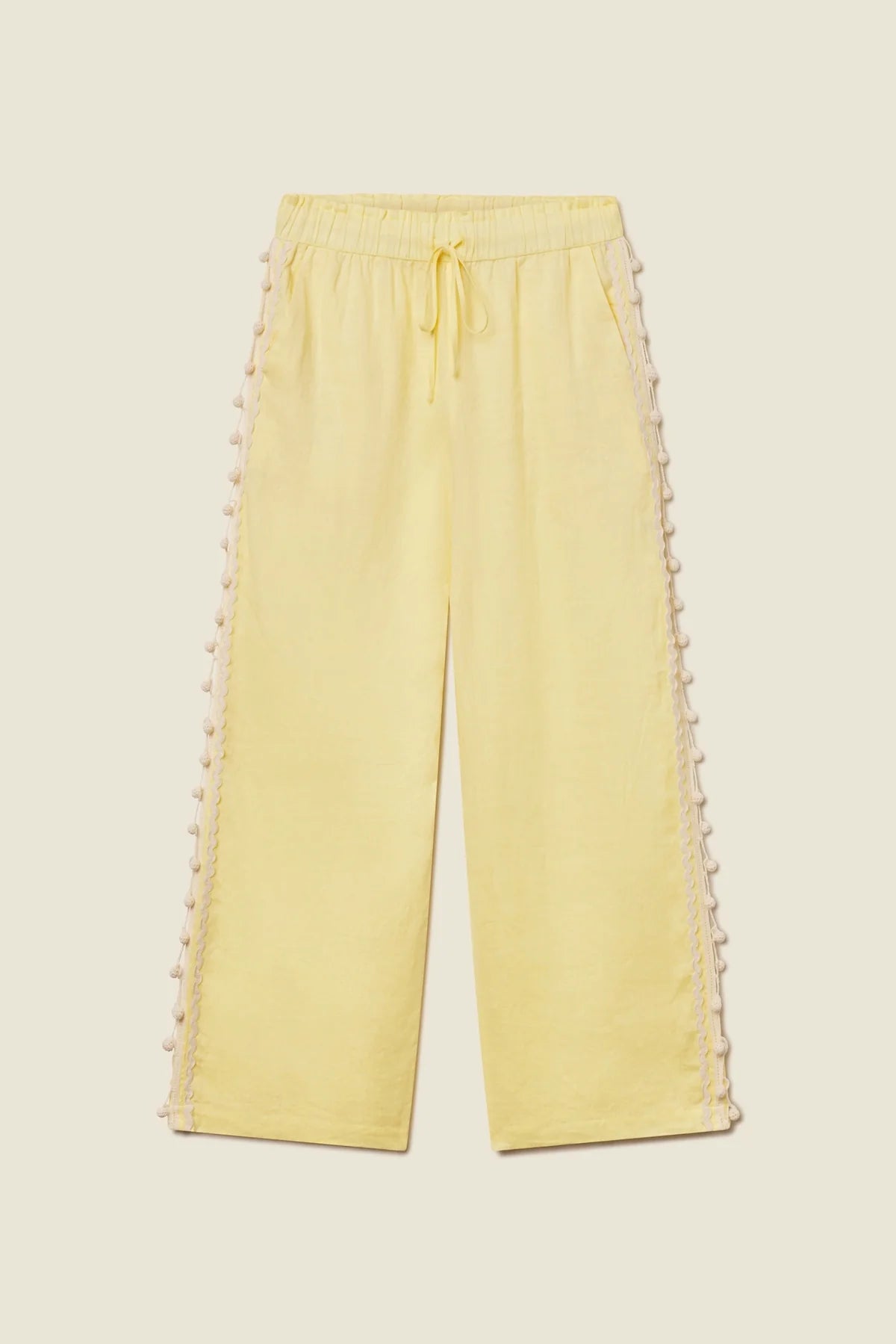 Yellow pants with lace trim on a beige background