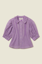 Purple checkered blouse on a beige background