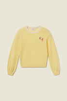 Yellow sweater with a small design on a beige background