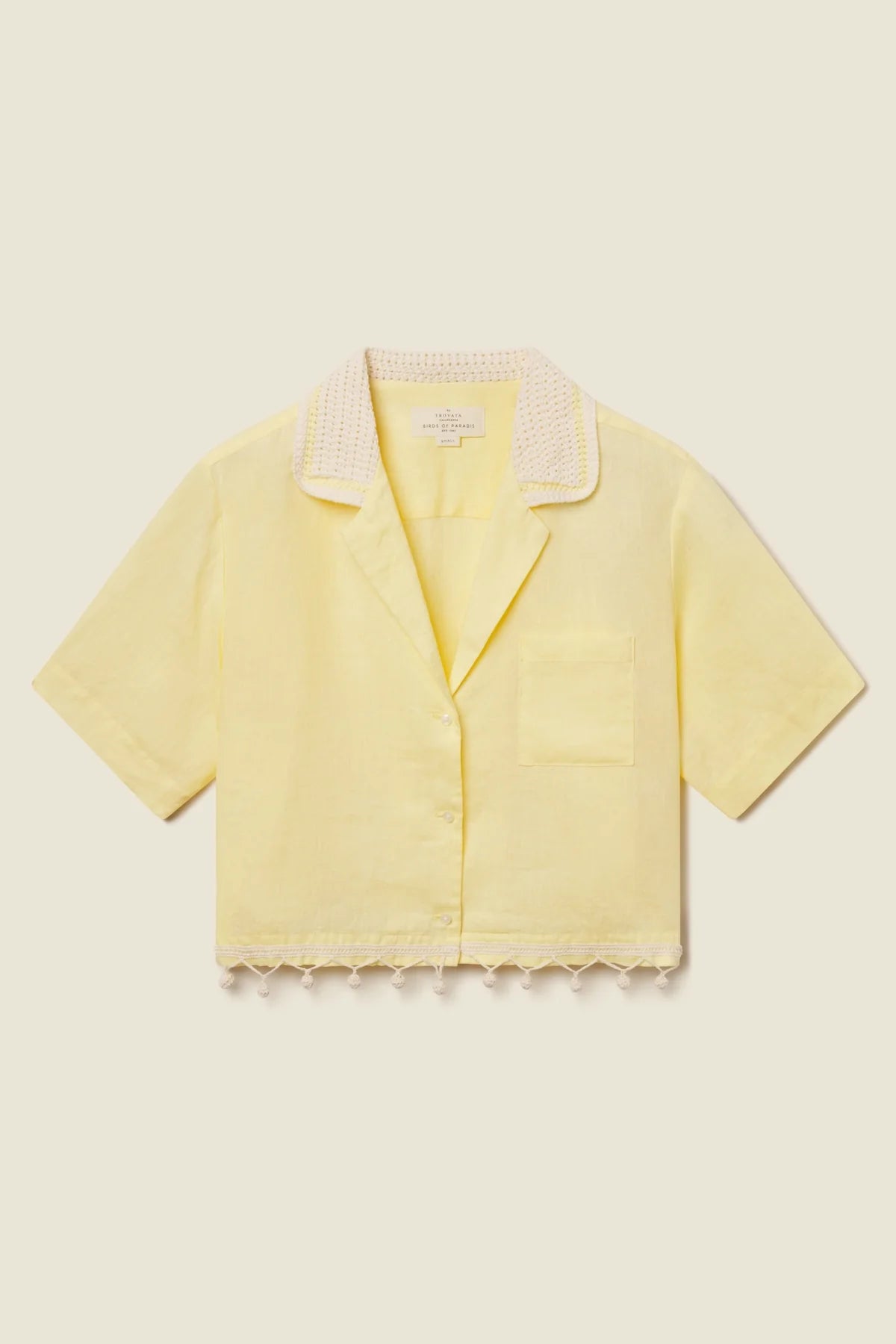 Yellow blouse with lace trim on a beige background