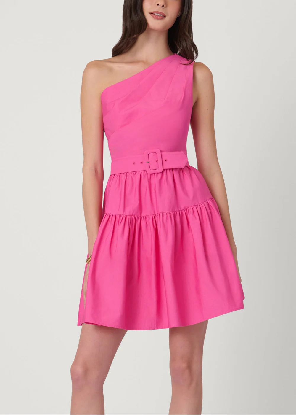 Pink one-shoulder dress worn by a model on a white background