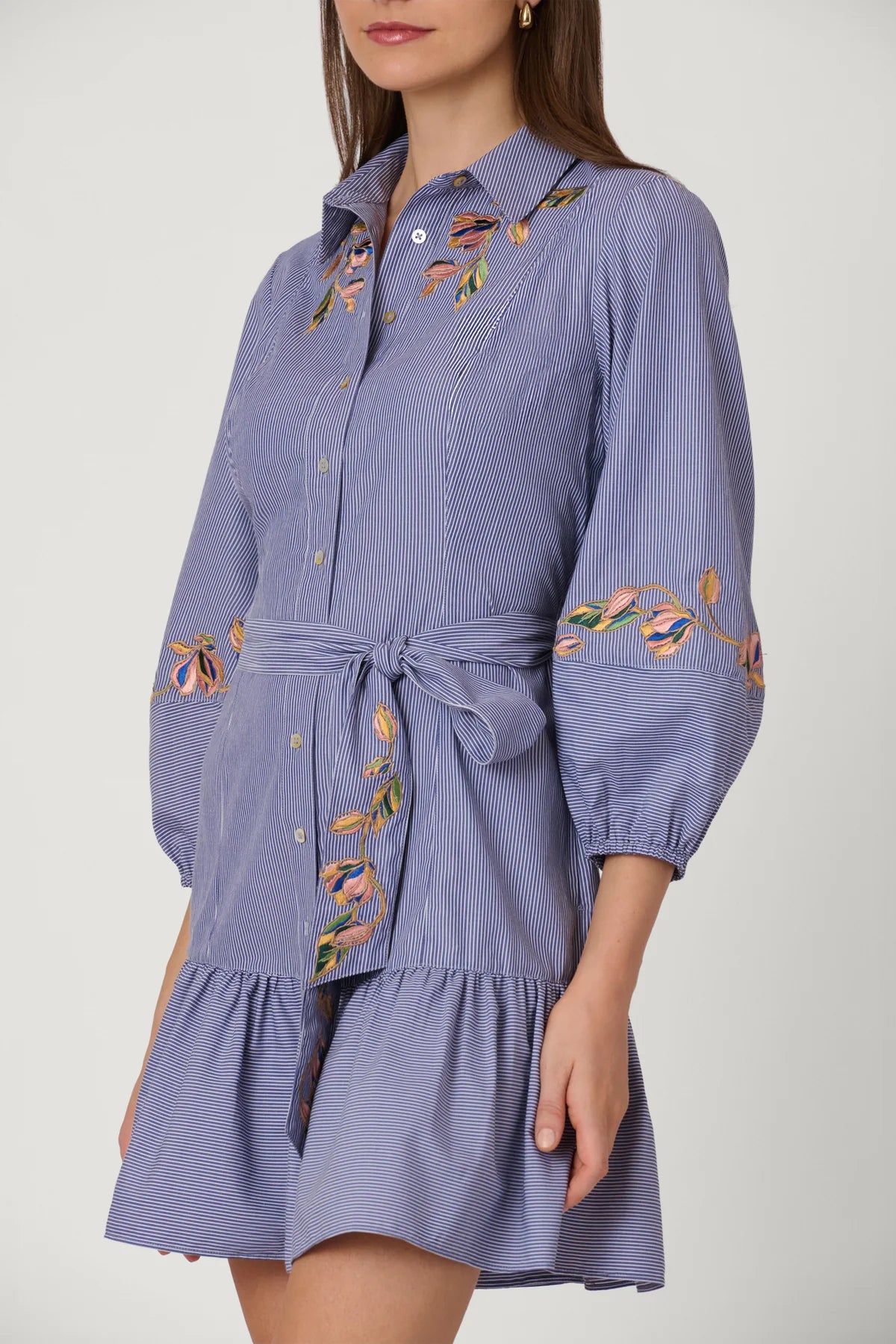 Blue dress with floral embroidery on a plain background
